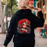 Person wearing a black hoodie with a colorful graphic design on the back, walking outdoors.