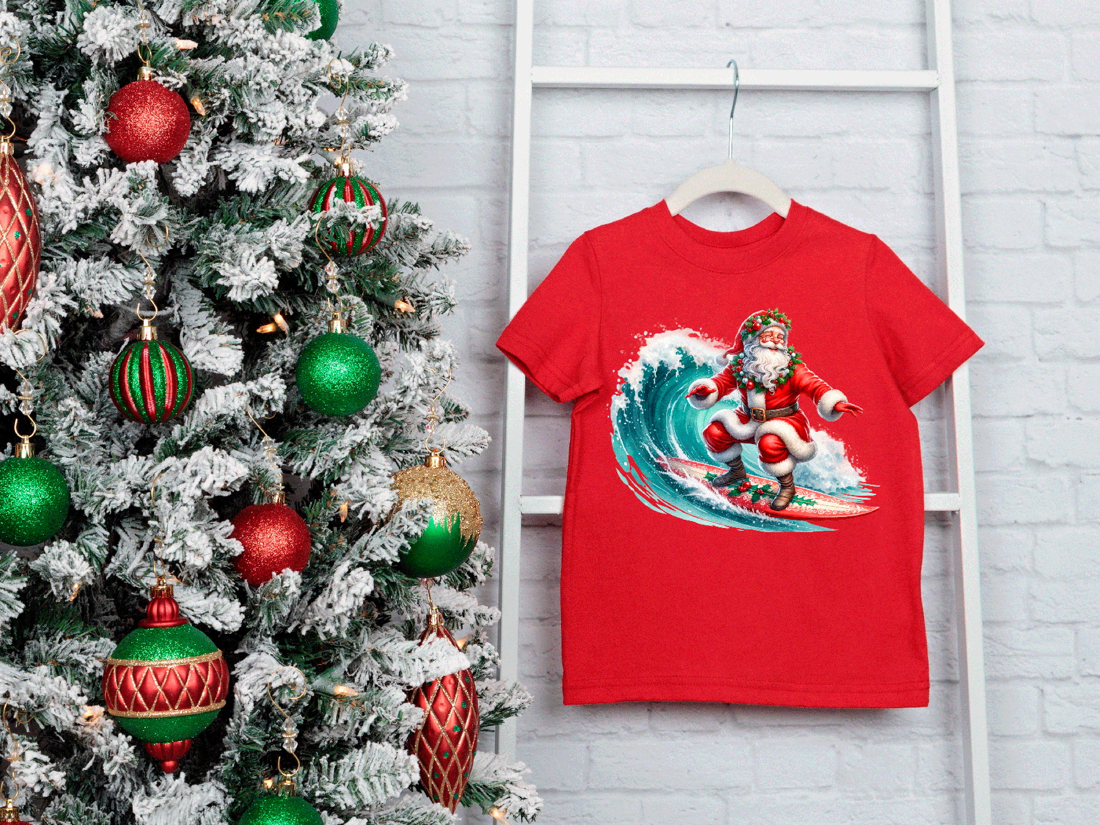 Red t-shirt with Santa Claus surfing design next to a decorated Christmas tree.