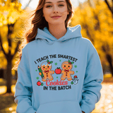 Person wearing a light blue hoodie with a gingerbread design and text in an autumn setting