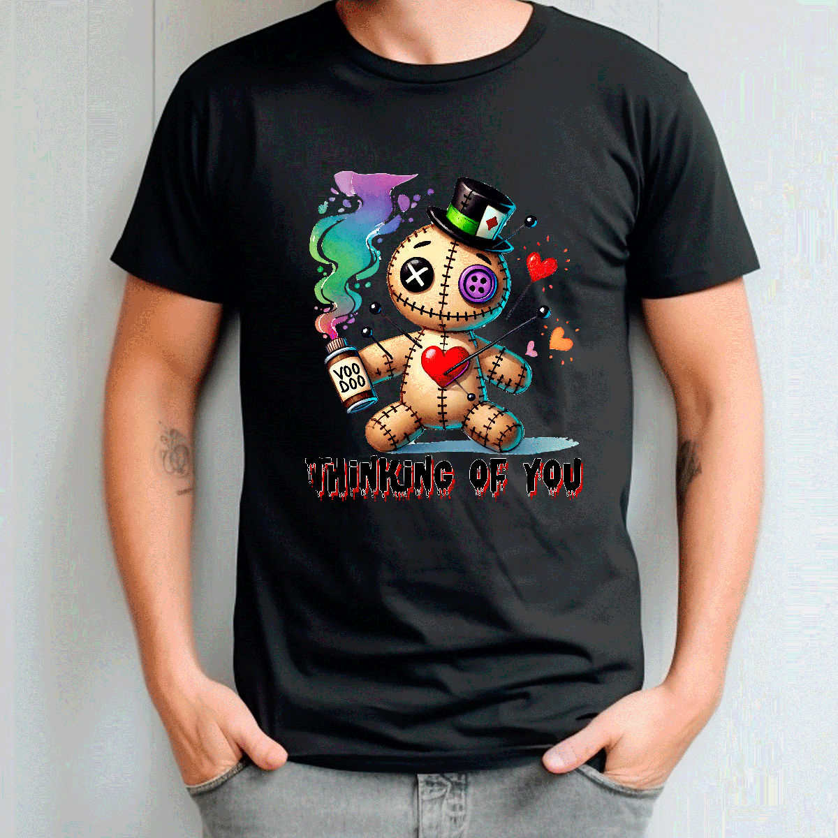 Person wearing a black t-shirt with a cartoon character and text 'Thinking of You' on a plain background