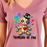 Pink t-shirt with a cartoon voodoo doll design and 'Thinking of You' text.
