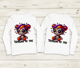 Two white long-sleeve shirts with a cartoon character and 'Thinking of You' text on a wooden surface.