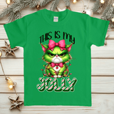 Green t-shirt with a festive design featuring a green cat with a pink bow and candy cane text on a wooden background.
