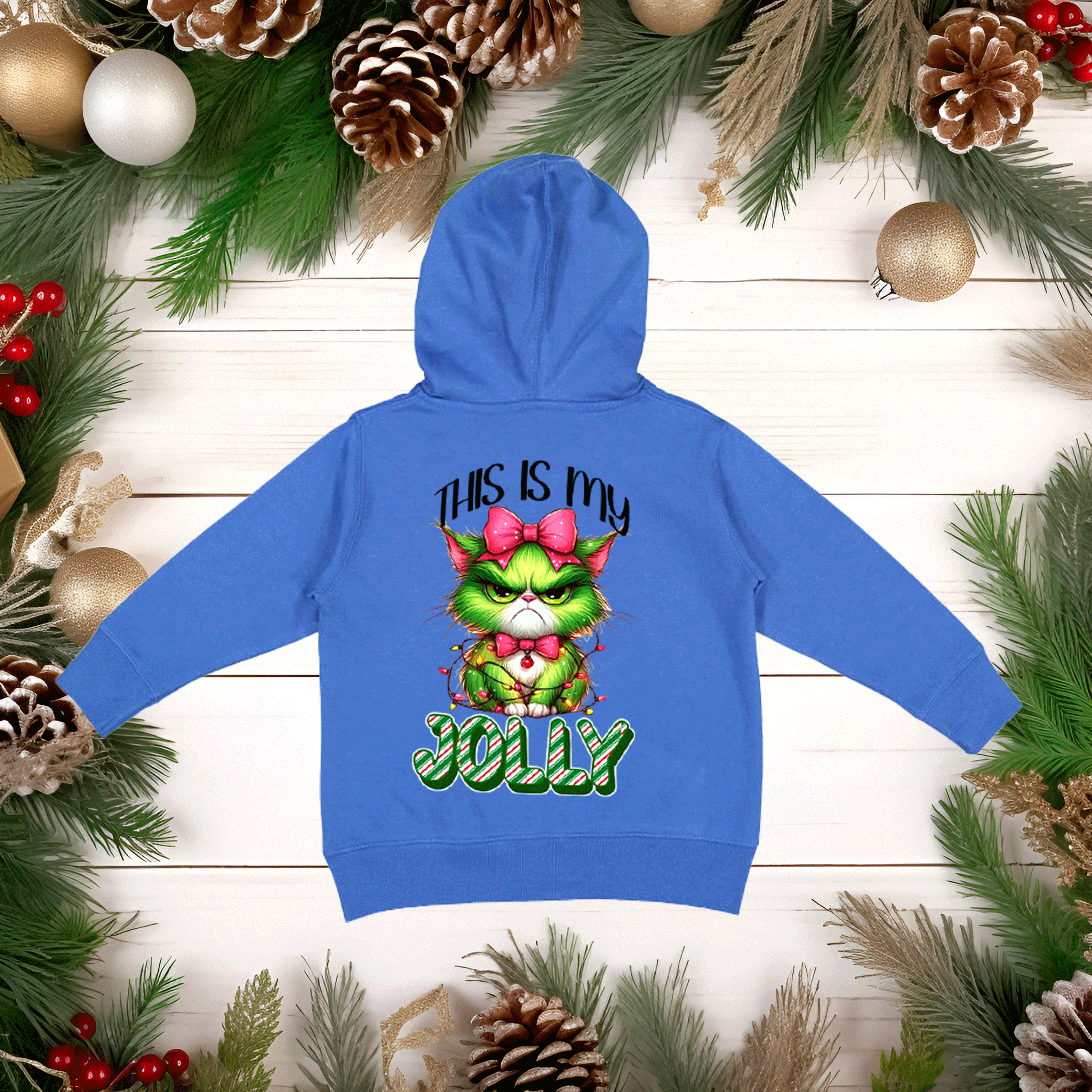 Blue hoodie with a Christmas-themed design on a wooden background with festive decorations.