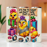 Three tumblers with cartoon chicks and gift boxes on a blurred background