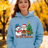 Person wearing a light blue hoodie with Christmas-themed design in an autumn setting
