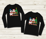 Black long-sleeve shirts with Christmas-themed designs on a wooden surface