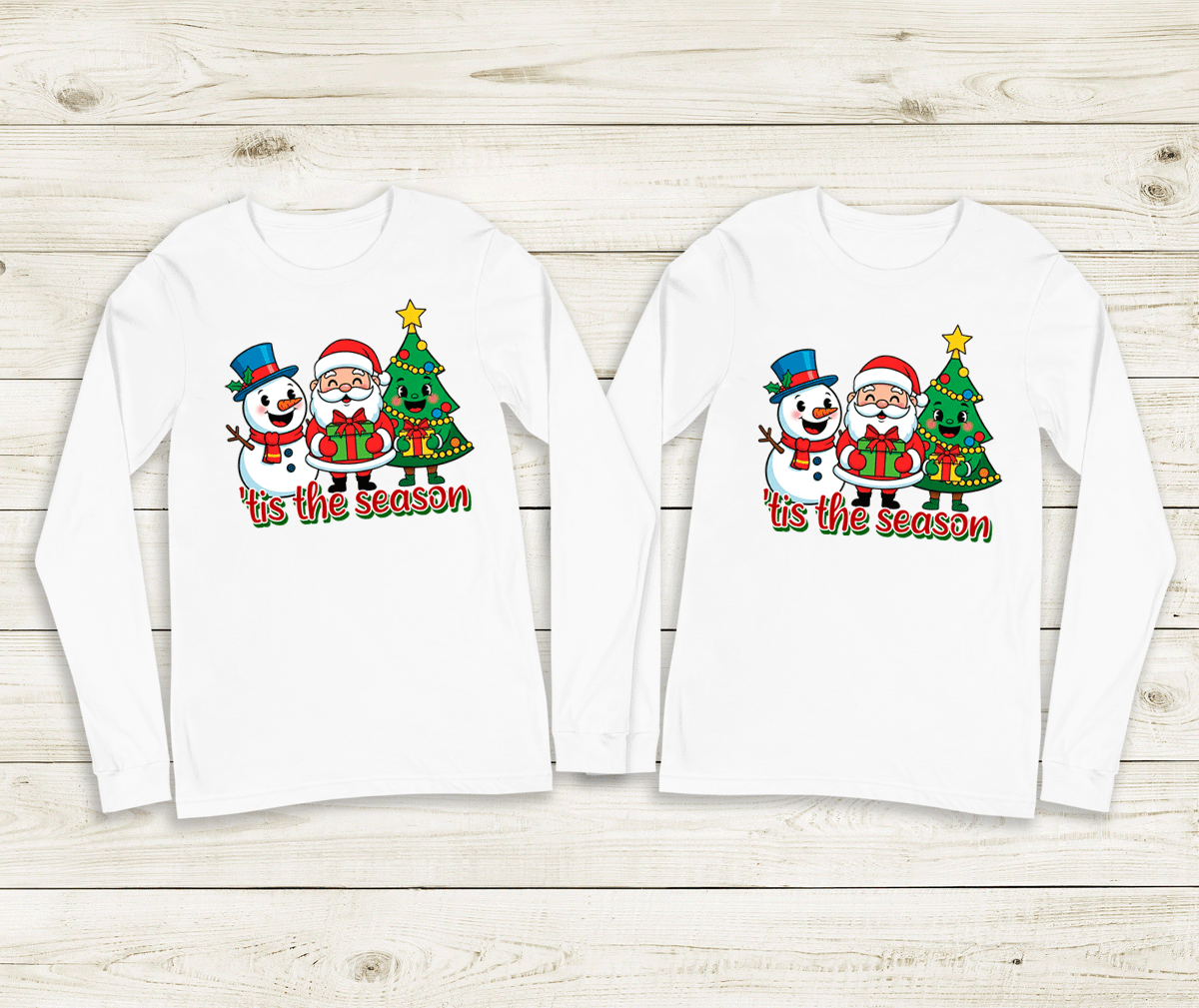 Two white long-sleeve shirts with Christmas-themed design on a wooden surface