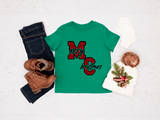 Green t-shirt with red plaid 'Merry Christmas' design, paired with jeans, boots, and a decorative bag on a light background.