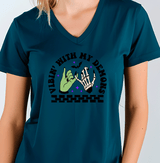 Person wearing a teal t-shirt with a graphic design and text.