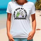 Person wearing a white t-shirt with a graphic design on a beach