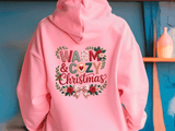 Pink hoodie with 'Warm & Cozy Christmas' text and floral design on a blue background