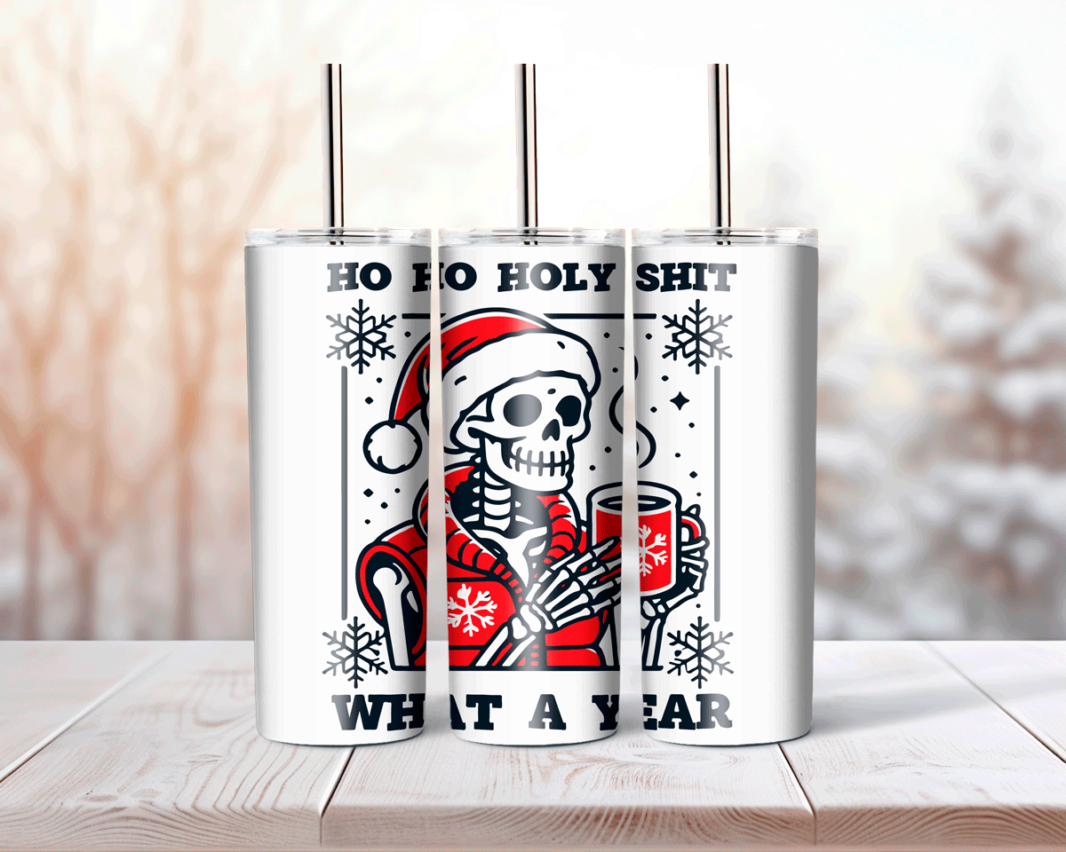 Tumbler with skeleton wearing a Santa hat and text 'Ho Ho Holy Shit, What a Year' on a wooden surface.