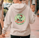 Person wearing a hoodie with a Christmas-themed skeleton design on the back, holding a coffee cup.