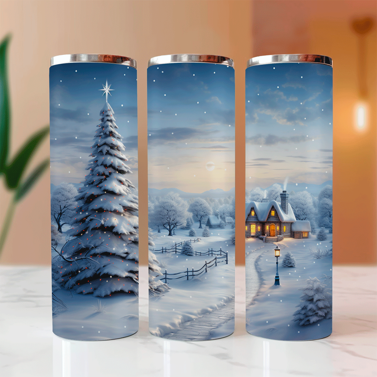 Three cylindrical tumblers with winter scene designs on a marble surface.