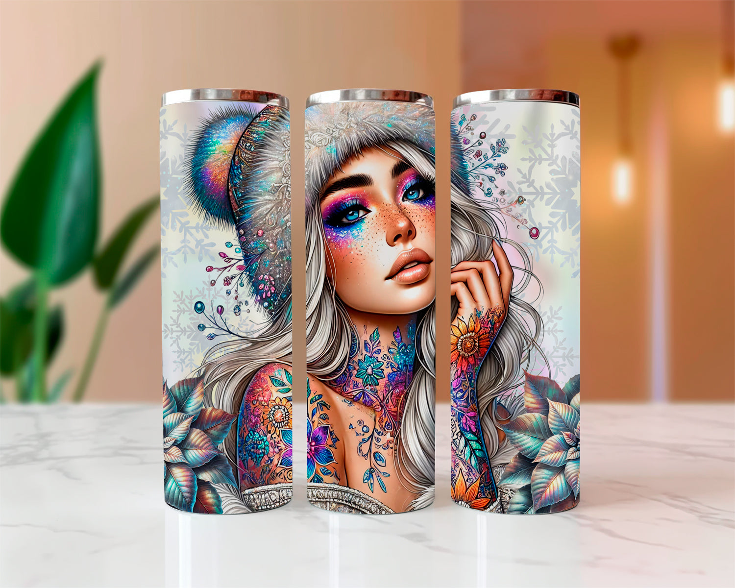 Three tumblers with artistic designs of a woman with colorful makeup and tattoos on a white surface.