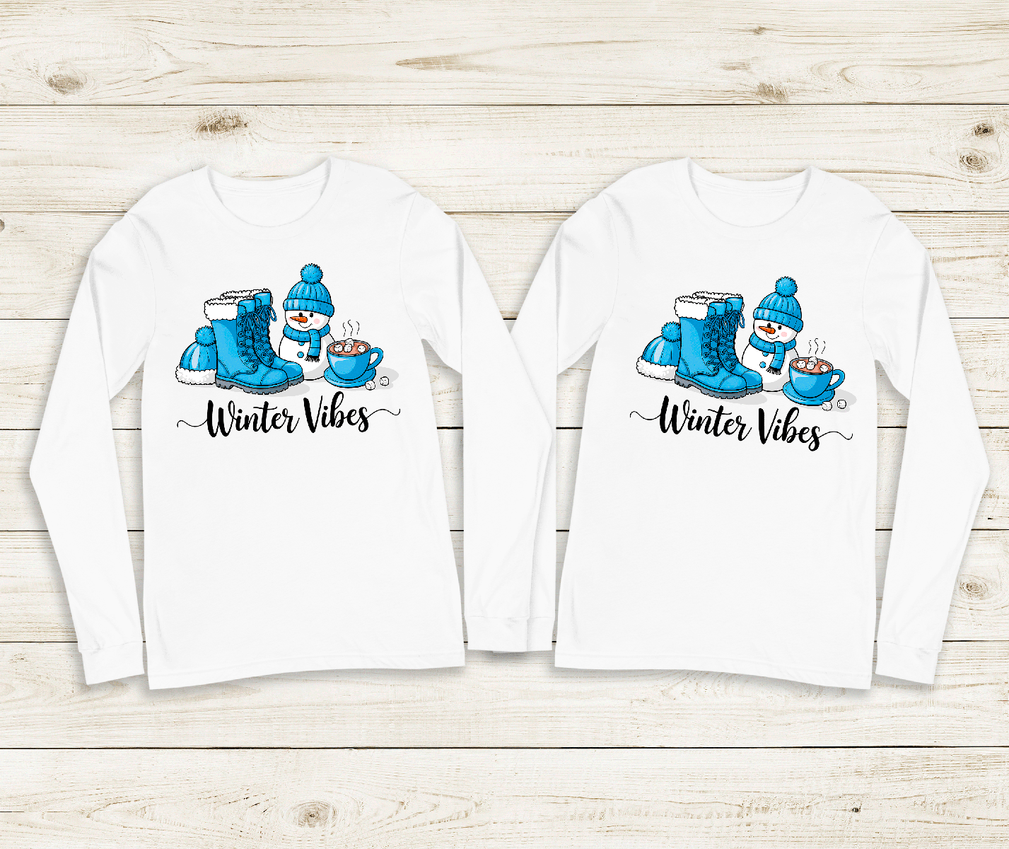 Two white long-sleeve shirts with winter-themed designs on a wooden surface.