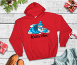 Red hoodie with 'Winter Vibes' design featuring boots and a snowman on a wooden surface.