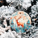 Decorative Christmas ornament with a deer design hanging on a snow-covered tree.