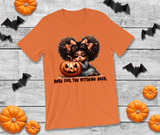 Orange t-shirt with Halloween-themed design featuring a child and pumpkin, surrounded by pumpkins and bats on a wooden surface.