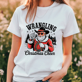 White t-shirt with 'Wrangling Christmas Cheer' design featuring a Santa Claus-like character.